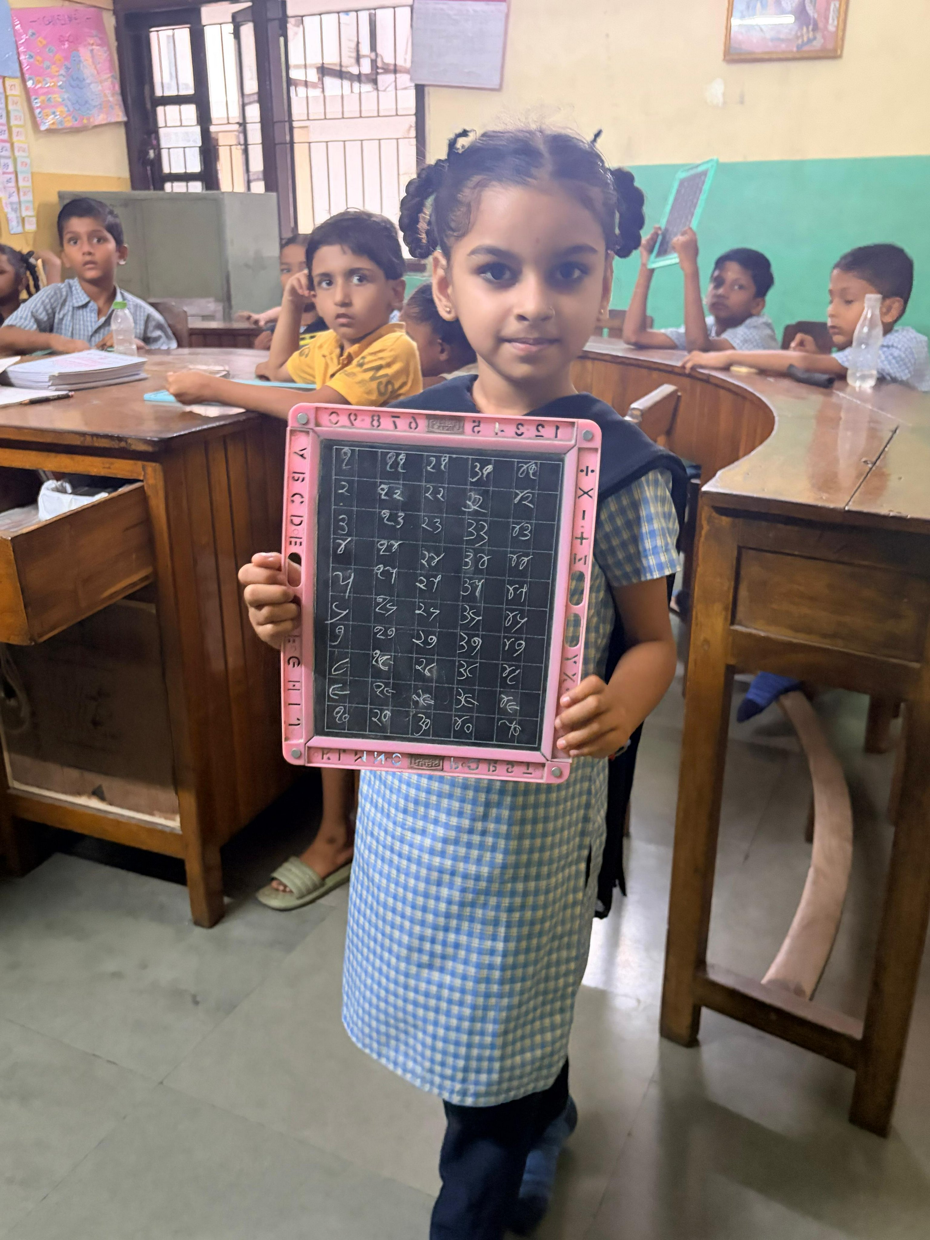 Deaf student showing mathematical calculations on slate
